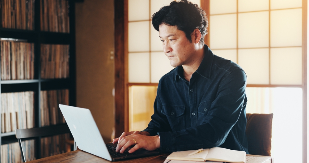 自宅で職務経歴書に向き合う40代後半の男性